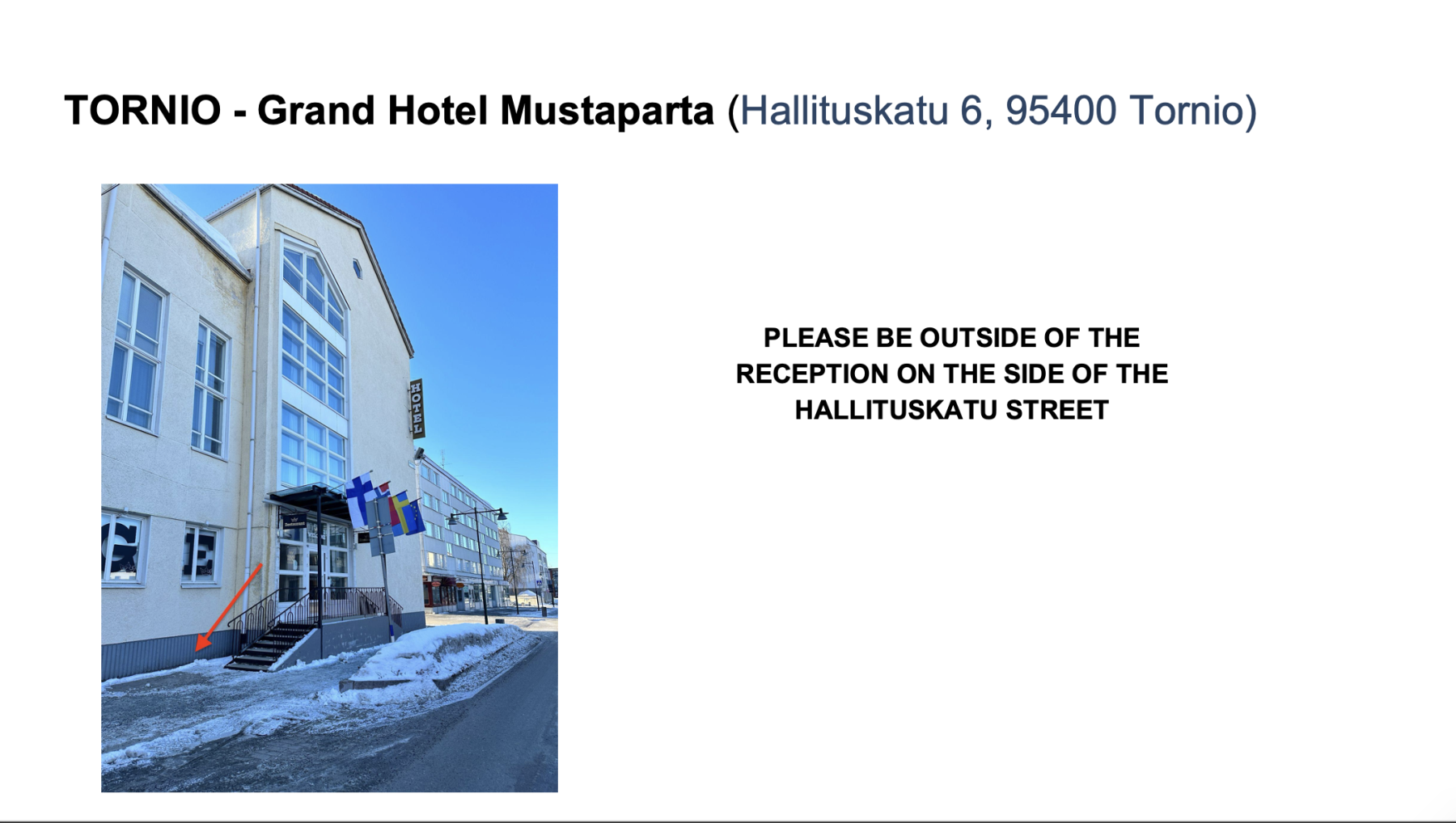 Exterior of Grand Hotel Mustaparta in Tornio with flags and snow-covered sidewalk beside street.